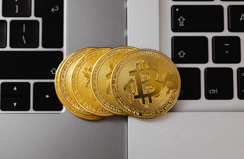 Digital Security: Protecting Your Online Financial Interactions Several gold Bitcoin coins stacked on a silver laptop keyboard