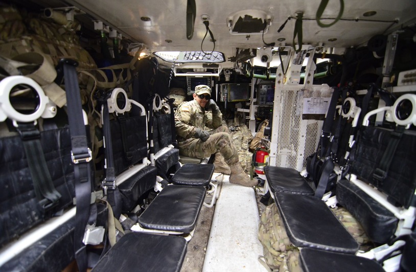 Redefining Readiness: What the AFT Signals About the Future of Soldier Fitness Soldier inside an armored vehicle, showcasing military equipment and seating.