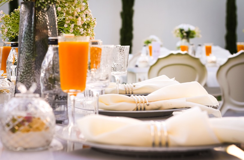 The Beauty Prep Mistakes That Ruin Elegant Event Styling Beautifully arranged dining table with orange drinks and white decor, perfect for outdoor events.