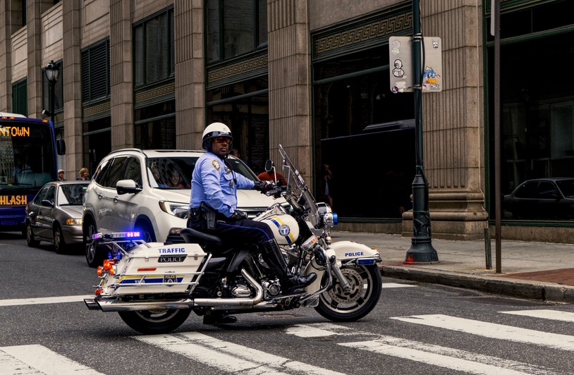 Washington Sees Motorcycle Fatalities Decline by Over 20%, Strengthening Traffic police officer riding a motorcycle in a busy city intersection.