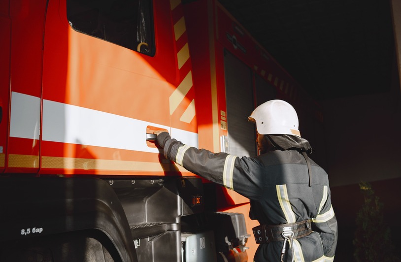 What Compensation Can Truck Accident Victims Get in Texas? Firefighter in safety gear working with a fire truck outdoors during the day.