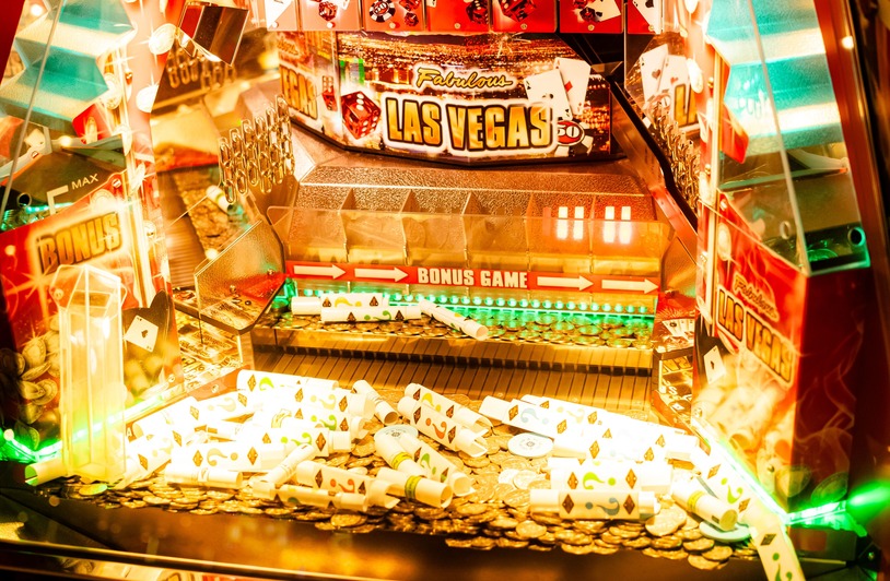 What is a No Deposit Bonus Casino? Colorful casino game machine featuring Las Vegas theme with coins and poker cards.