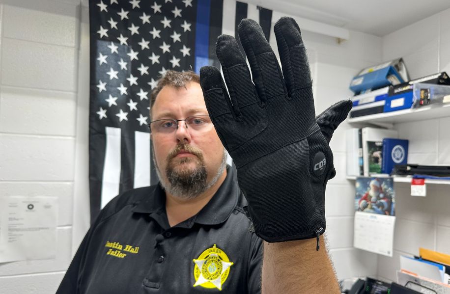 Sheriff holding electrified gloves