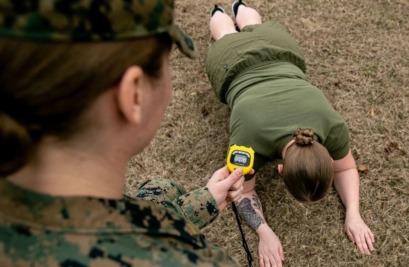 Female Marine completes a plank for fitness test