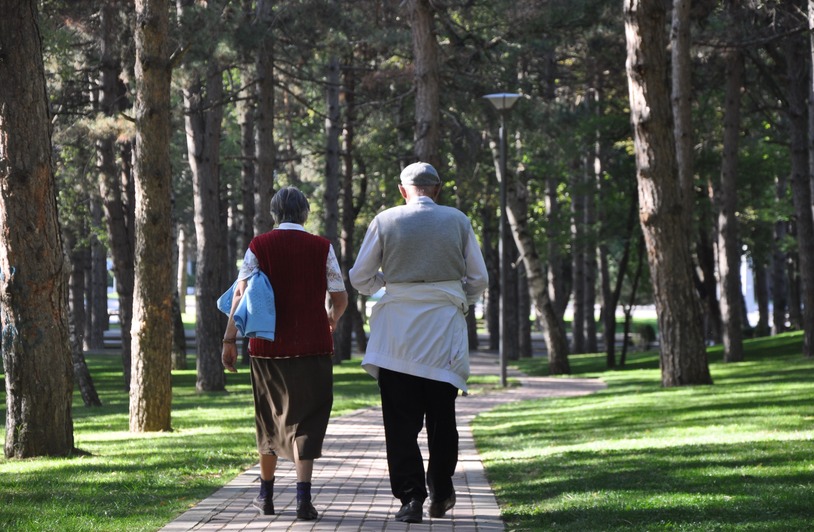 DCR-adult-pull-up-diapers-Insert1 A man and a woman walking on a pathway between trees