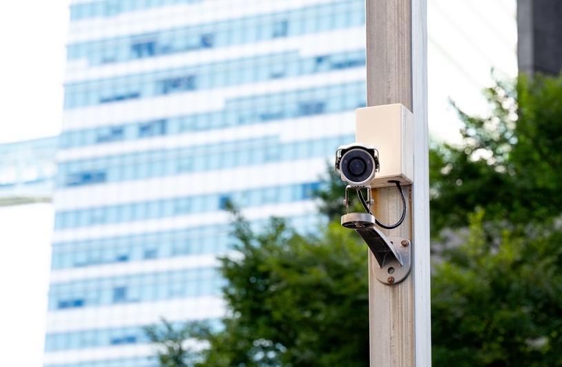 How Data Forensics Supports Public Safety Initiatives Security camera mounted on a pole with a building in the background