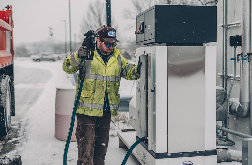 Fitting Gas Rewards Into Smarter Retirement Spending Man standing at a gas pump filling up a car.