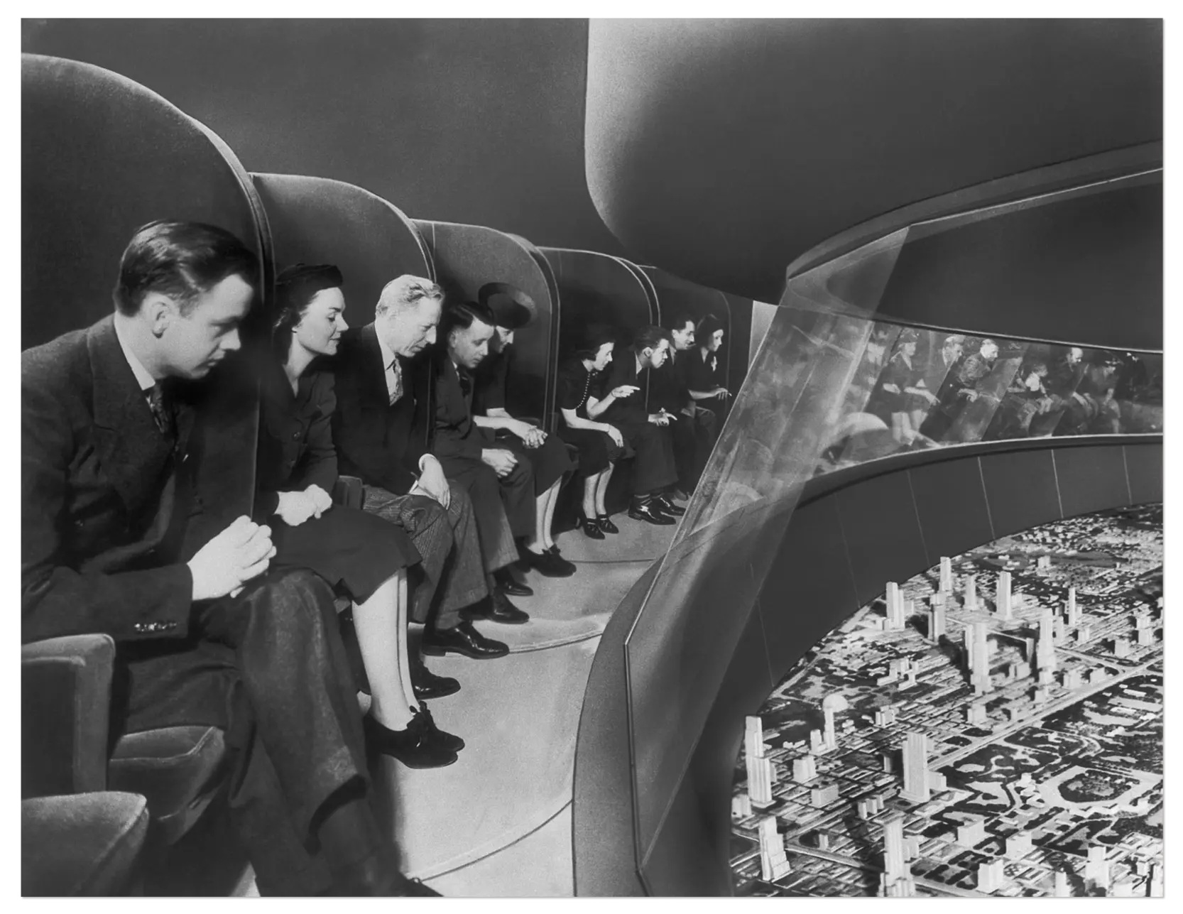 Photo of people peering over at a futuristic model city below