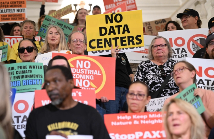 Protesters hold signs that say “No data centers” and “No industrial zoning.”