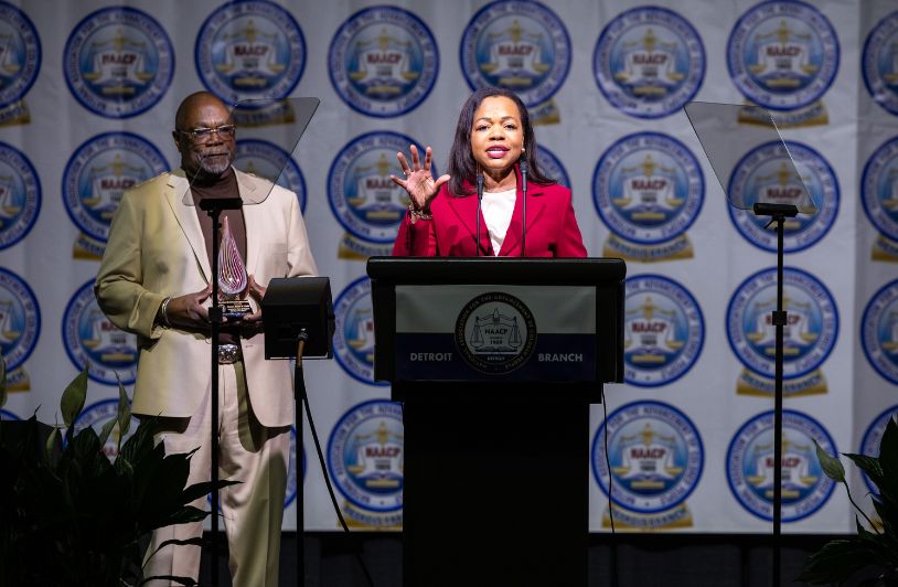 Kristen Clarke stands at podium